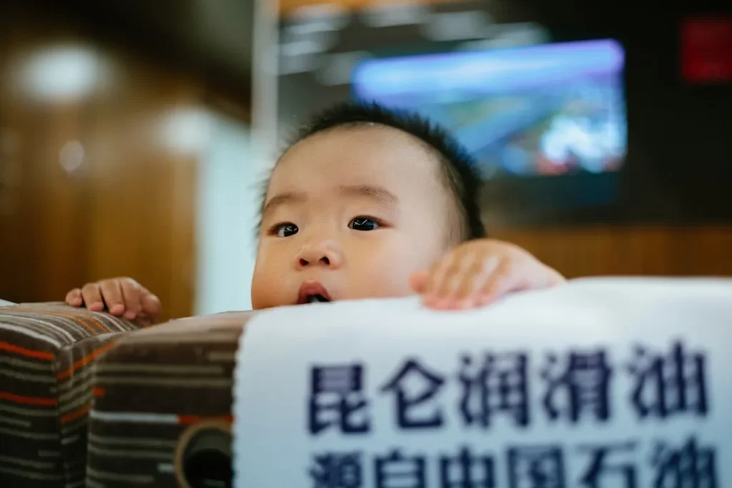 a baby is peeking out from behind a sign