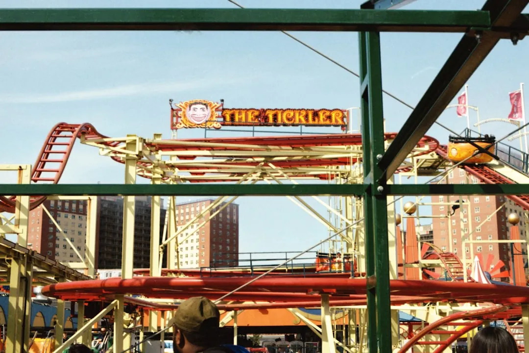 a group of people standing in front of a roller coaster