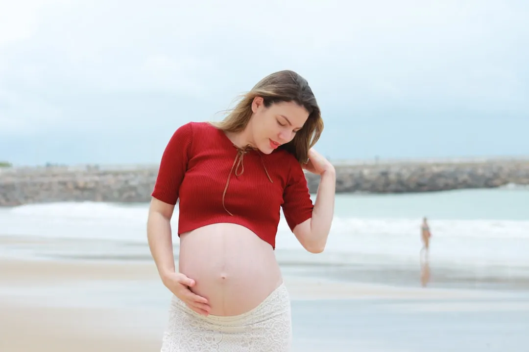 pregnant woman standing beside beach