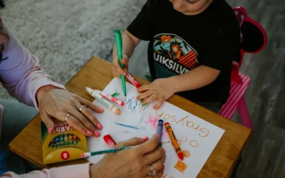 boy in black crew neck t-shirt holding green pen