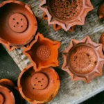 Several clay diyas arranged on a textured surface
