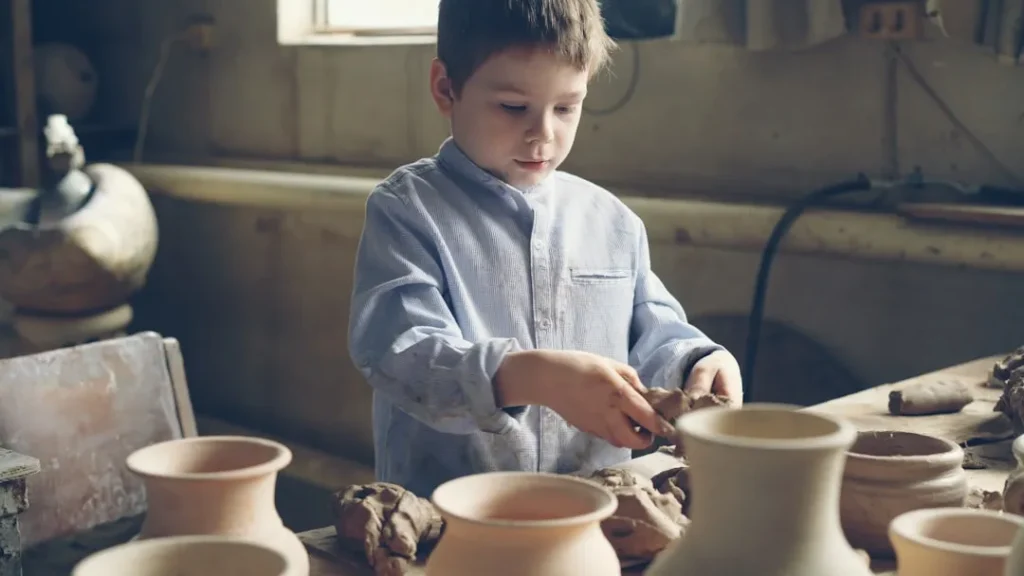 A young boy crafts pottery.