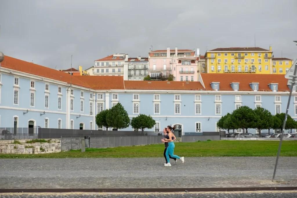 A woman walking down a street in front of a blue building