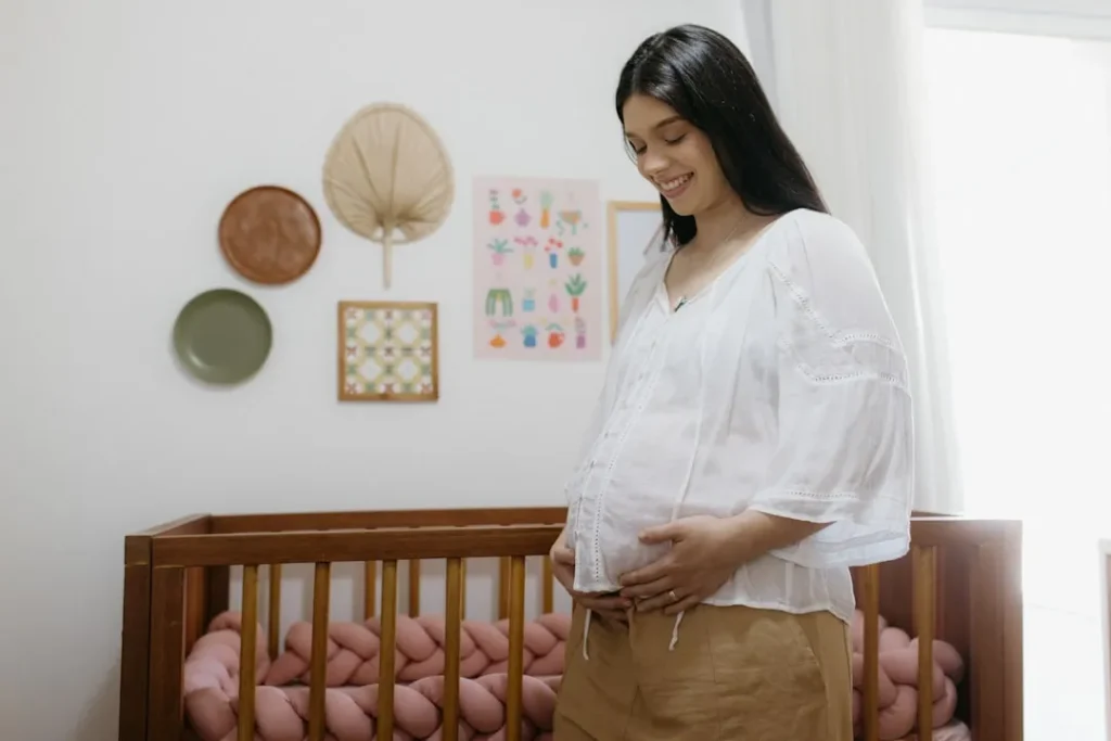 A woman standing next to a baby crib