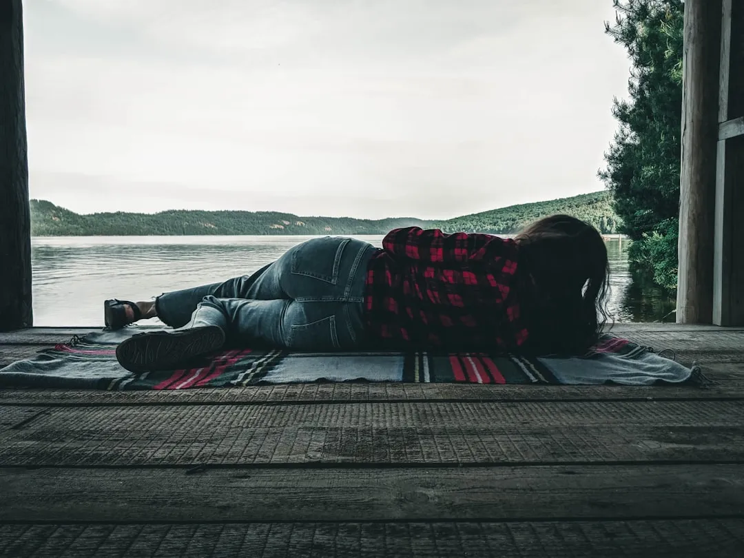 a woman laying on a rug on a porch