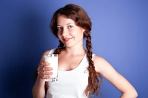 A young woman holding a glass of milk