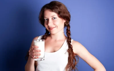 A young woman holding a glass of milk
