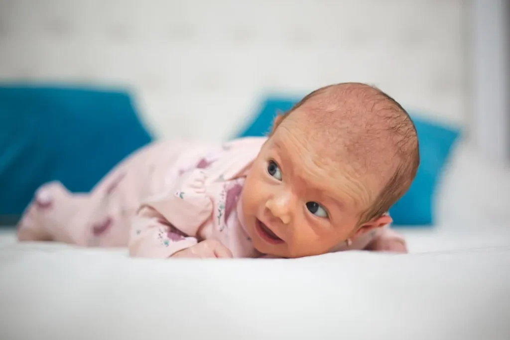 Newborn baby lying on stomach looking to the side