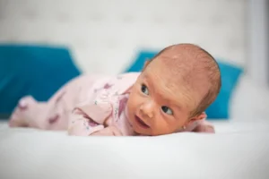 Newborn baby lying on stomach looking to the side