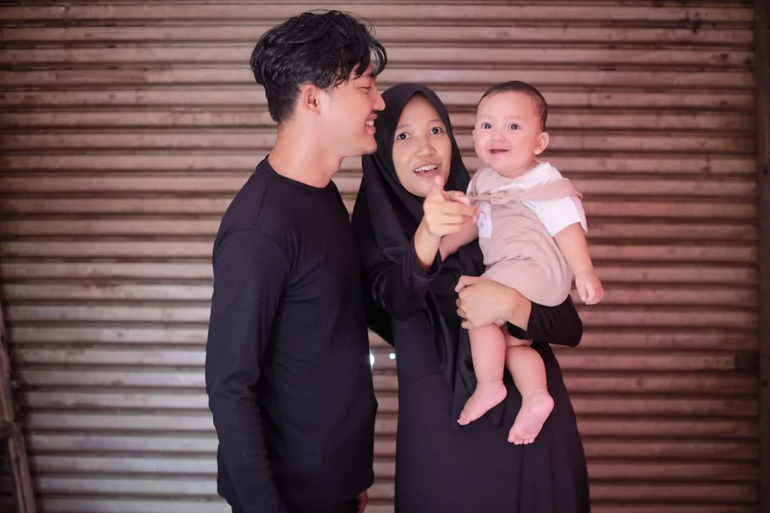 a man and a woman are holding a baby
