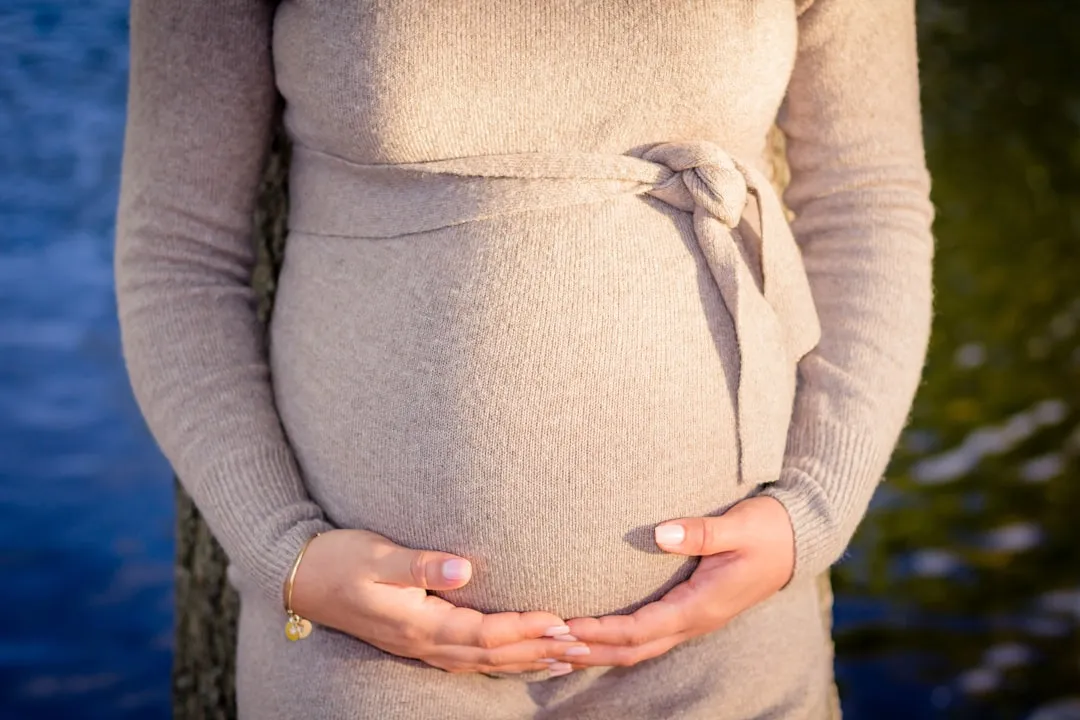 a pregnant woman holding her belly in her hands