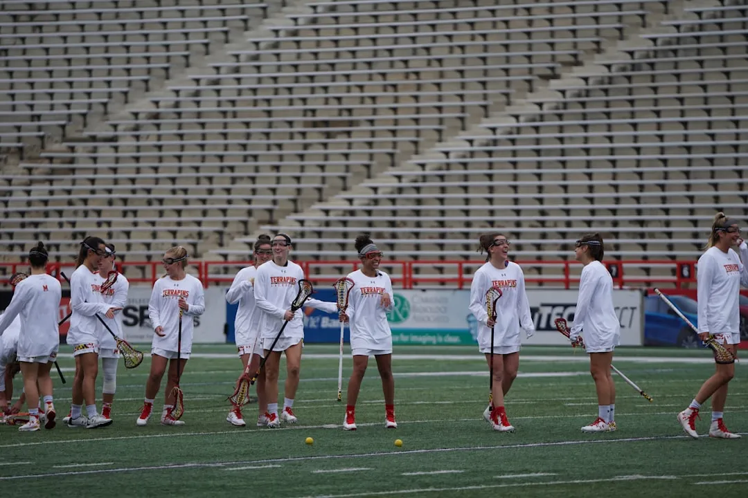 group of women playing lacrosse during daytime