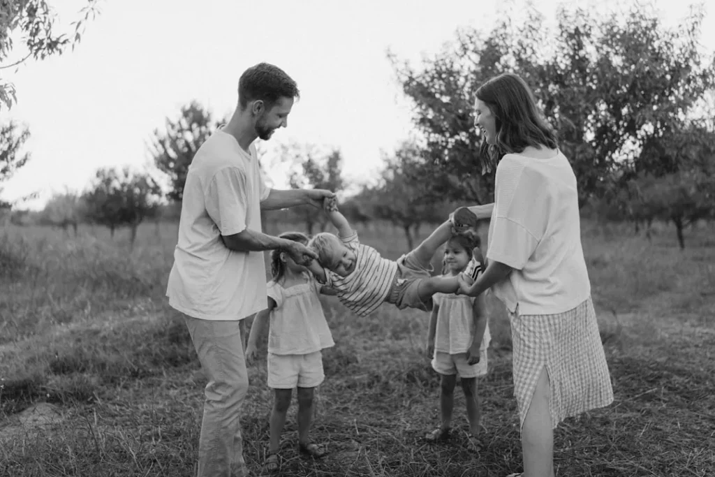 Family playing with child in grassy field