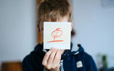 boy holds white card with drawing