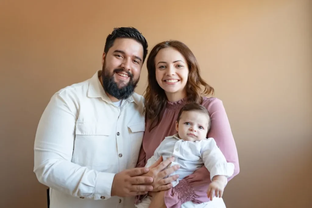 a man and a woman pose for a picture with a baby