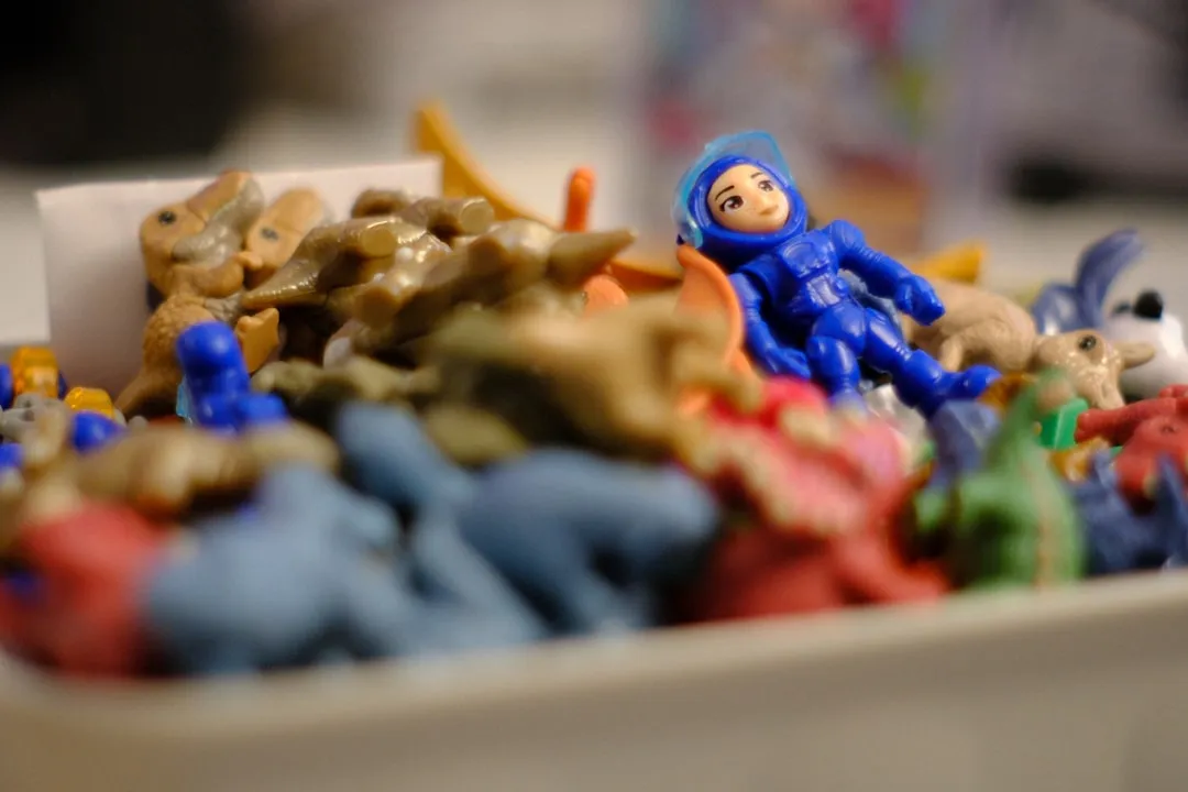 A blue astronaut toy among many colorful small toys.