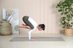 a woman is doing a yoga pose on a mat