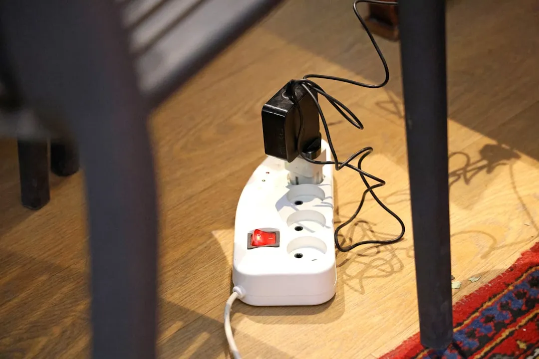 White power strip with plugs on a wooden floor.