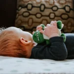 baby lying on white bed