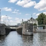 Canal lock with historic building in the background