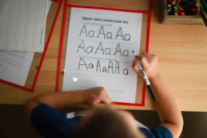 a young boy writing on a piece of paper