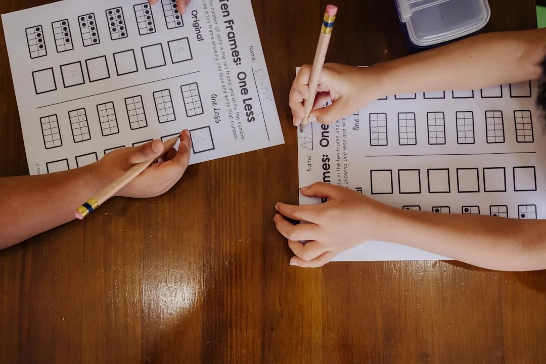 A couple of people sitting at a table with paper