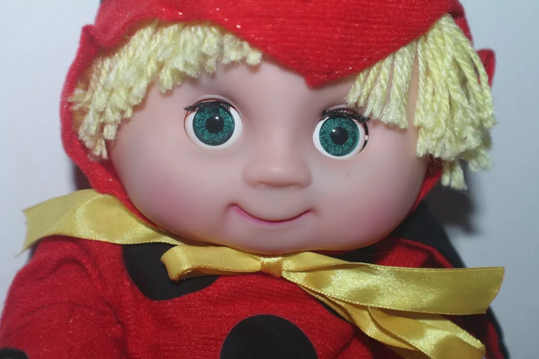 a close up of a doll wearing a red outfit