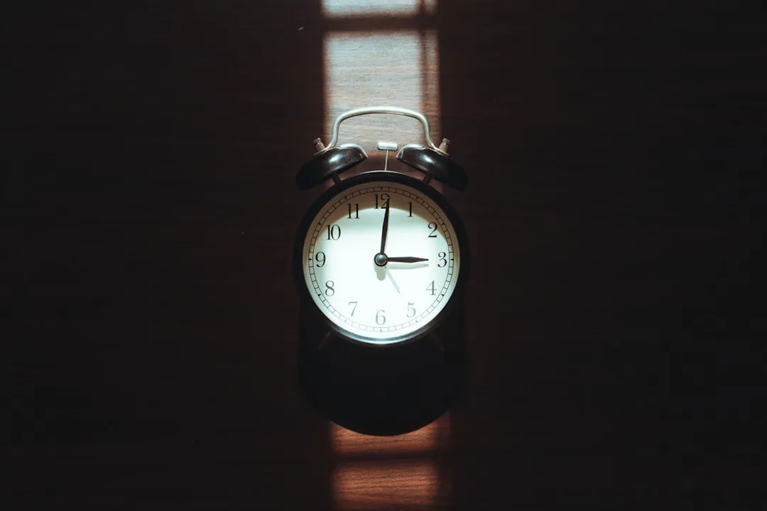 Alarm clock casting a shadow on a dark surface