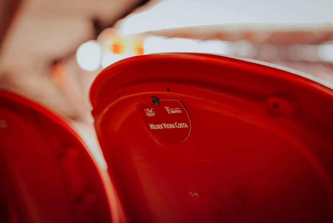 Close-up of red stadium seats with a small sticker.