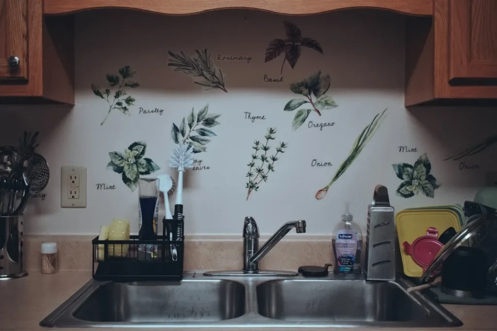 Kitchen sink area with herb decals on wall