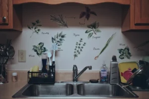 Kitchen sink area with herb decals on wall